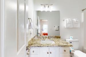 a white bathroom with a sink and a mirror at Sunset Bay in Dauphin Island +32 photos