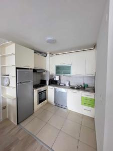 - une petite cuisine avec des armoires et des appareils blancs dans l'établissement Sarajevo Apartments, à Sarajevo