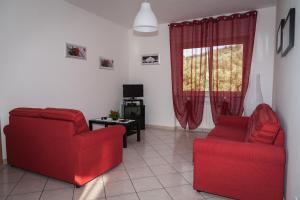 una sala de estar con 2 sillas rojas y una ventana en Casa Vacanze Relax, en Agropoli