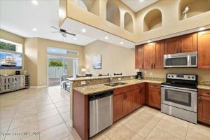 una grande cucina con armadietti in legno ed elettrodomestici in acciaio inossidabile di Luxury Villa near beach a Indian Harbour Beach