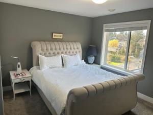 Un dormitorio con una cama grande y una ventana en Galloping Goose B&B in Beautiful Victoria, en Victoria