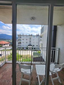 - un balcon avec deux chaises et une vue sur un bâtiment dans l'établissement Sarajevo Apartments, à Sarajevo
