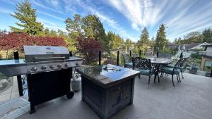 een buitenkeuken met een grill en een tafel en stoelen bij Galloping Goose B&B in Beautiful Victoria in Victoria