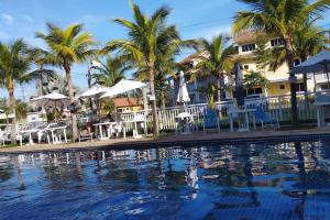una piscina frente a un hotel con palmeras en Tranquilidade e diversão, en Mangaratiba