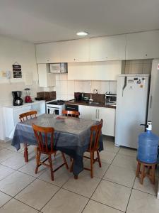 cocina con mesa, sillas y nevera en Lindo flat sem custos adicionais, en Natal