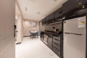 a kitchen with a refrigerator and a table with chairs at زهرة in Buraymān