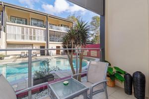a balcony with a swimming pool and a building at Eden by the Bay in Hervey Bay