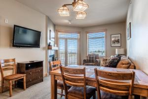 a living room with a dining room table and a tv at Sunstone # 329 in Mammoth Lakes