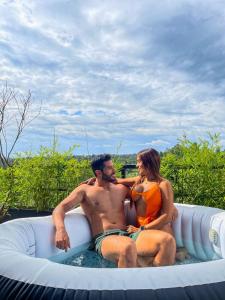 a man and a woman sitting in an inflatable pool at Glamping Malu in Popayan