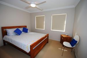a bedroom with a bed and a chair in it at Spectacular - Belle Escapes Jervis Bay in Vincentia