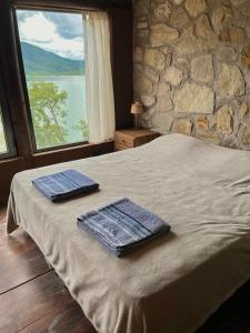 two towels on a bed in a room with a window at Cabañas Cabra Corral in Coronel Moldes