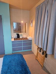a bathroom with a blue sink and a blue rug at Di's B&B in Matamata