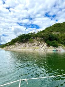 ein Boot im Wasser neben einer kleinen Insel in der Unterkunft Cabañas Cabra Corral in Cabra Corral