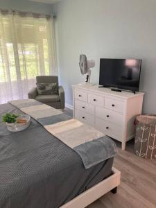 um quarto com uma cama, uma televisão e uma cadeira em All season paradise in Cortez em Bradenton