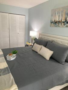 a bedroom with a large bed with gray sheets and pillows at Golf Coast Charmer in Bradenton +31 photos