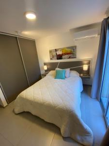 a bedroom with a bed with a white comforter at In Calma Mdz in Mendoza