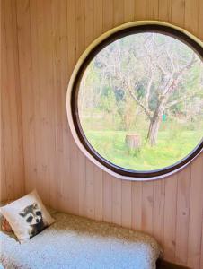 - une fenêtre ronde dans une chambre avec un oreiller dans l'établissement Riberas del Futa, à Valdivia