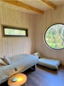 um quarto com uma cama e uma janela redonda em Riberas del Futa em Valdivia