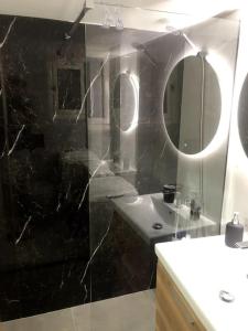 een badkamer met een douche, een wastafel en een spiegel bij athens oasis in Athene