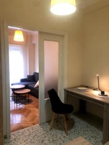 een woonkamer met een zwarte stoel en een tafel bij athens oasis in Athene