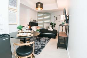 a living room with a table and a couch at Resort Condo Unit with Stunning View - Azure North in Lagundi