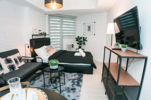 a living room with a bed and a couch at Resort Condo Unit with Stunning View - Azure North in Lagundi