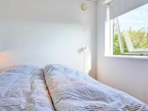 een bed in een witte kamer met een raam bij Holiday home Allinge XXIX in Allinge