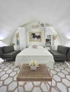 ein Schlafzimmer mit einem Bett, zwei Sofas und einem Tisch in der Unterkunft Villa Tropez in Saint-Tropez