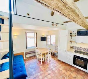 ein Wohnzimmer mit einem Tisch und einer Küche in der Unterkunft Villa Tropez in Saint-Tropez