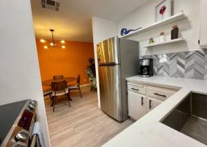 a kitchen with a stainless steel refrigerator and a table at MCM Condo Downtown Palm Springs in Palm Springs