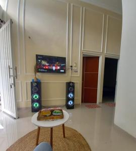 ein Wohnzimmer mit Fernseher und Lautsprechern und einem Tisch in der Unterkunft Kavilla10 Permata Garden Batu in Batu