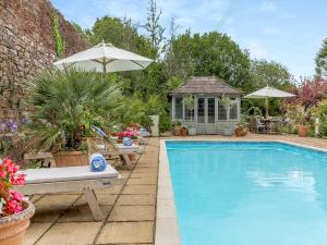 a swimming pool with chairs and a gazebo at Lower Blagdon Manor in Paignton