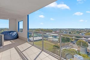 a balcony with a view of a city at Proximity Waterfront Apartments in Redcliffe