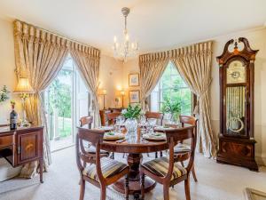 a dining room with a table and chairs and a clock at Lower Blagdon Manor in Paignton