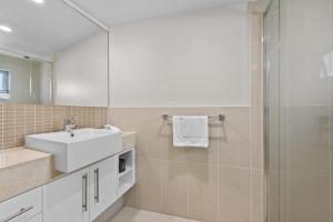 uma casa de banho com um lavatório e um chuveiro em Proximity Waterfront Apartments em Redcliffe