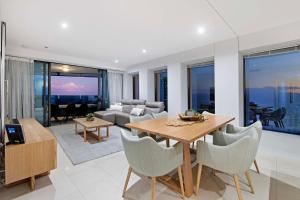 ein Wohnzimmer mit einem Holztisch und Stühlen in der Unterkunft Soul Beachfront Apartments - Hosted by Wow Stay in Gold Coast