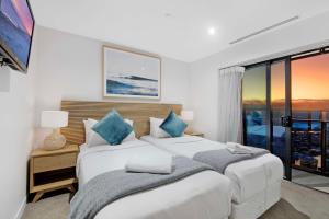 ein Schlafzimmer mit zwei Betten und einem großen Fenster in der Unterkunft Soul Beachfront Apartments - Hosted by Wow Stay in Gold Coast + 34 Fotos