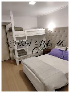 a bedroom with two beds and two bunk beds at Hotel Ruta 66 Oficial in Paso de los Libres