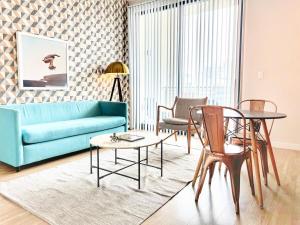 - un salon avec un canapé, une table et des chaises dans l'établissement The Leo - One Bedroom Apartment W Private Balcony, à San Diego