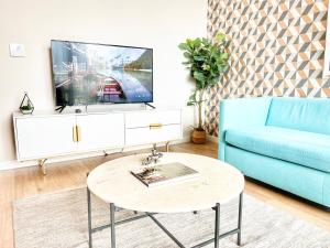 un soggiorno con divano blu e TV di The Leo - One Bedroom Apartment W Private Balcony a San Diego