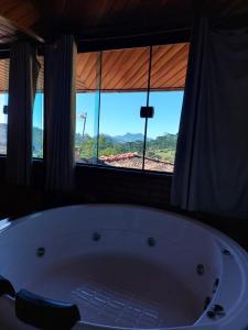 Cette chambre dispose d'une grande baignoire et d'une fenêtre. dans l'établissement Casa do Índio, à Visconde de Mauá