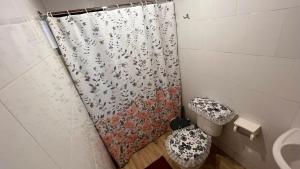 a bathroom with a shower curtain with a toilet at Cabaña Vista Bella in Pelluhue