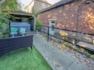 un patio avec un banc à côté d'un bâtiment en briques dans l'établissement Old Hall Cottage No 1, à Byers Green