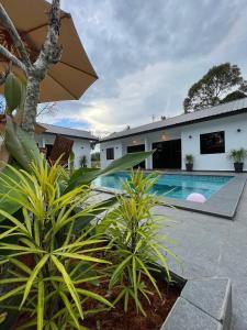 a villa with a swimming pool and a house at Villa The Quarry in Segamat