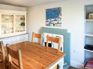 a dining room with a table and a fireplace at Hepzibah Cottage in Broad Haven