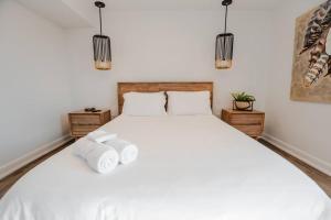 um quarto com uma cama branca com duas toalhas em Khlozy Escape the ordinary. (Feonho) em Cornwall
