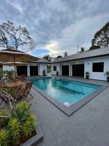 a swimming pool in front of a house at Villa The Quarry in Segamat