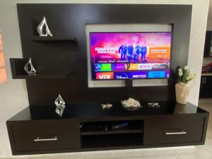 a black entertainment center with a flat screen tv at Acapulco Diamante hermoso departamento in Acapulco