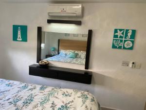 1 dormitorio con 1 cama y espejo en la pared en Acapulco Diamante hermoso departamento, en Acapulco
