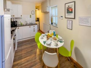 uma cozinha com uma mesa e cadeiras verdes num quarto em Old Hall Cottage No 1 em Byers Green